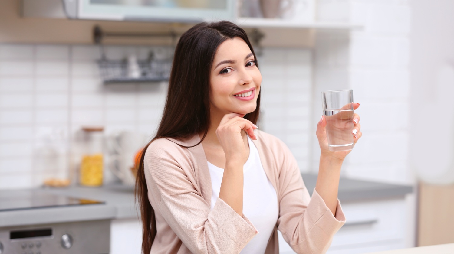 Feature | Woman holding a glass of water in the kitchen | Reasons to Love Tyent Water Ionziers, Part 9: Tyent Alkaline Water Is The Healthiest Water In The World. Dare To Compare! | healthiest water to drink